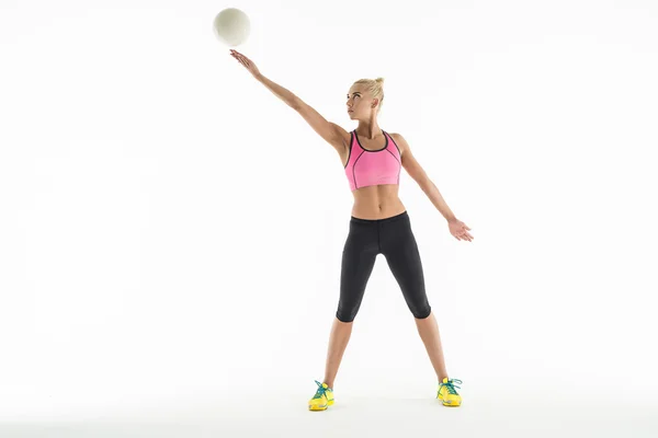 Художественная гимнастка делает упражнения с мячом в студии . — стоковое фото