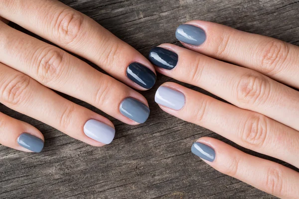Mooie handen met de miniatuur geschilderd in een grijs gekleurd — Stockfoto