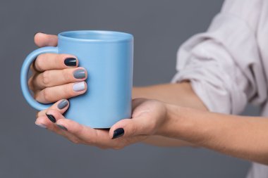 Female hands with blue cup