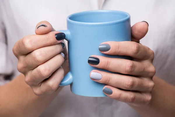 Female hands with blue cup — Stockfoto