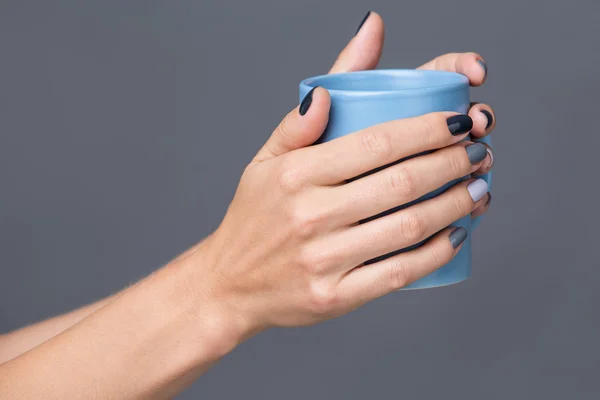 Female hands with blue cup — Stockfoto