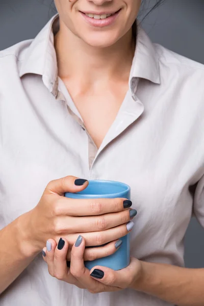 Mãos femininas com copo azul — Fotografia de Stock