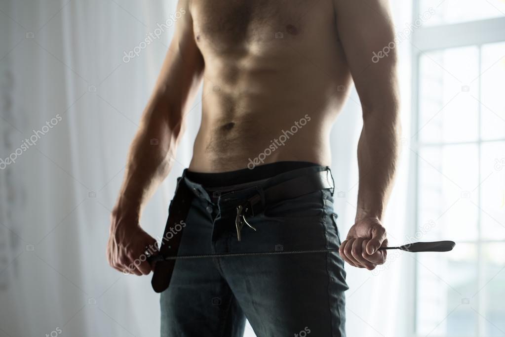 Handsome guy topless with whip BDSM Stock Photo by ©bezikus 79995600
