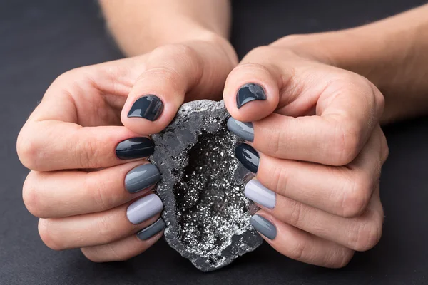 Vrouwelijke handen met getextureerde zilveren minerale — Stockfoto