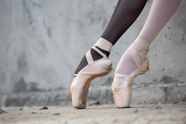 Ballerina-Füße in Nahaufnahme auf einem Hintergrund aus strukturiertem Beton — Stockfoto