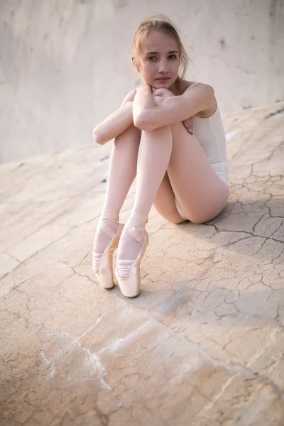 Slim dancer sitting on a concrete surface — Stok fotoğraf