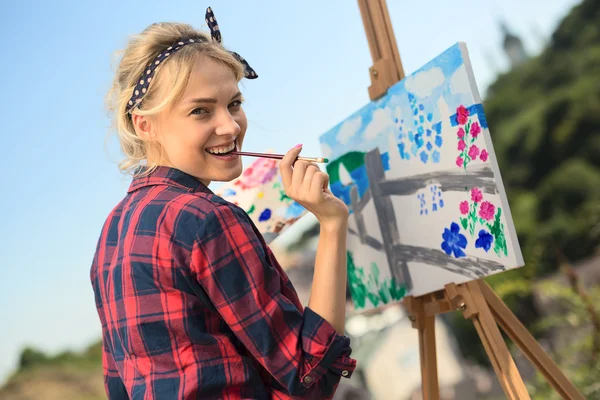 Gyönyörű szőke nő művész egy színes képet fest. — Stock Fotó