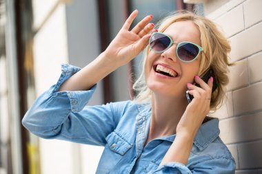 Sevimli sarışın cep telefonundan konuşuyor.