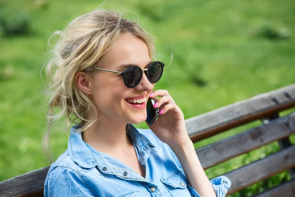 Χαριτωμένο ξανθιά, μιλάμε για ένα κινητό τηλέφωνο. — Φωτογραφία Αρχείου