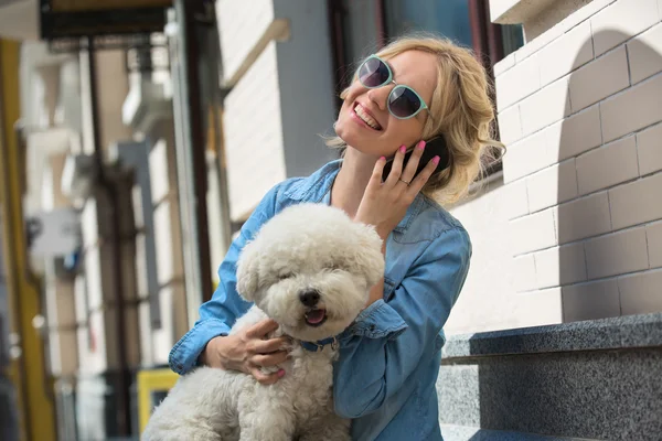 Schattige blonde met Bichon Frise witte hond — Stockfoto