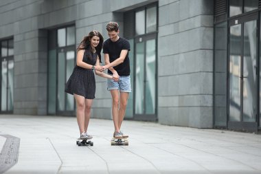 Şık genç aşık genç çifti longboards binmek