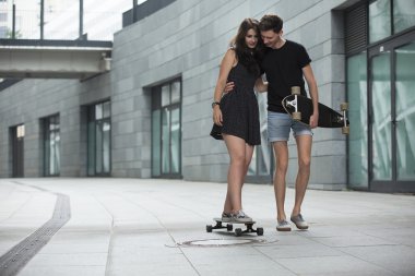 Şık genç aşık genç çifti longboards binmek