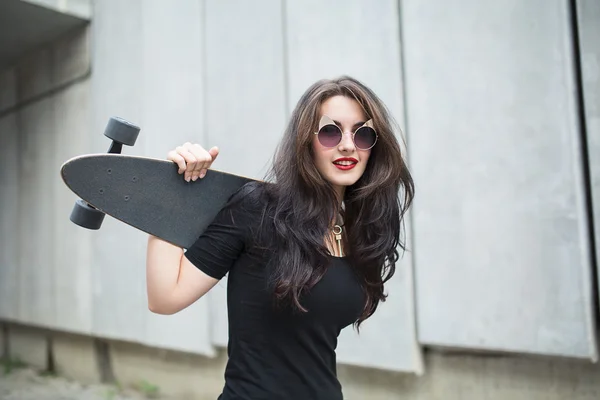 Stilvolles Teenager-Mädchen mit einem Longboard — Stockfoto