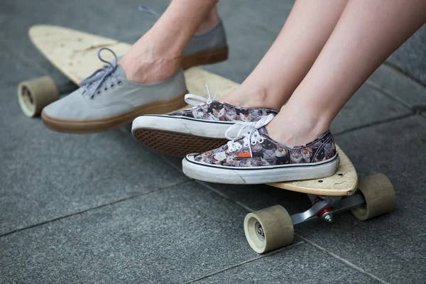 Pies par de adolescentes en el longboard primer plano —  Fotos de Stock