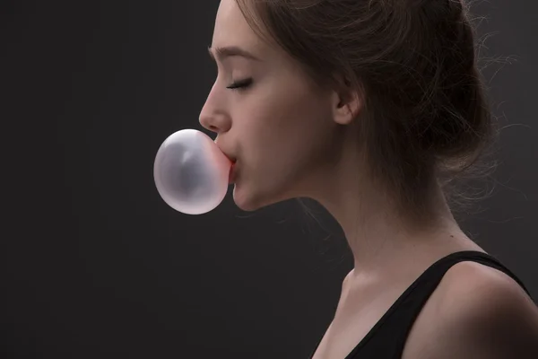 Девушка с розовым пузырём жевательной резинки — стоковое фото