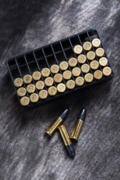 Scattering of small caliber cartridges on a wooden background — Stock Photo, Image