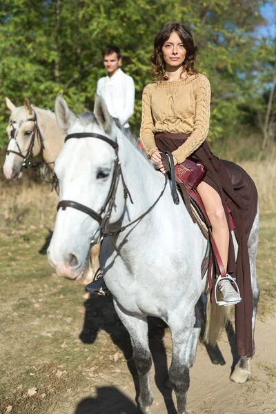 Pareja joven enamorada montando un caballo — Foto de Stock