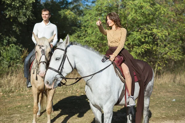 Jeune couple amoureux chevauchant un cheval — Photo