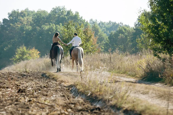 年轻夫妇骑一匹马的爱情 — 图库照片