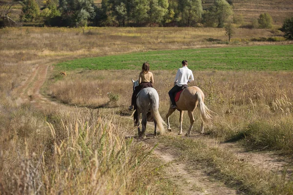 Pareja joven enamorada montando un caballo —  Fotos de Stock