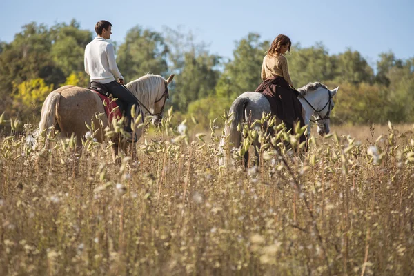 Jong paar in liefde berijden van een paard — Stockfoto