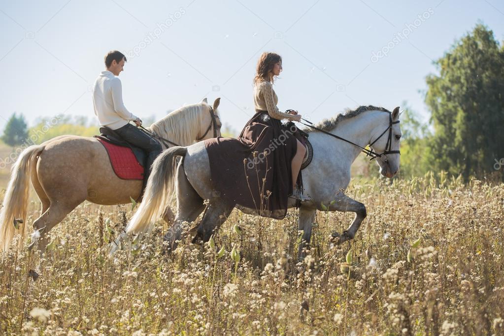 Young couple in love riding a horse