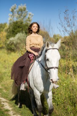 Güzel kız beyaz bir at sürme