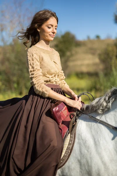 Schönes Mädchen reitet auf einem weißen Pferd — Stockfoto