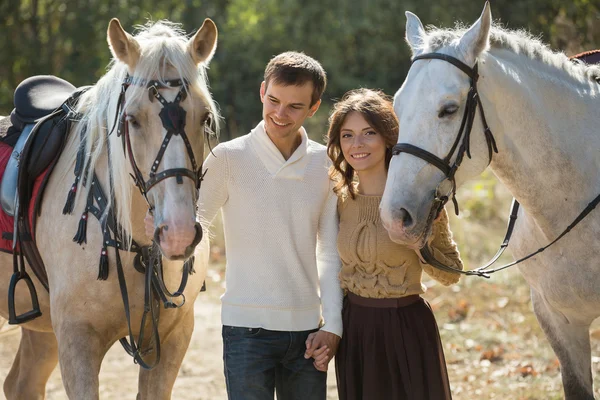 Молода пара гуляє в мальовничому місці з конями — стокове фото