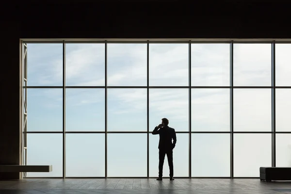 Stilvoller Geschäftsmann im Hintergrund eines großen Fensters — Stockfoto