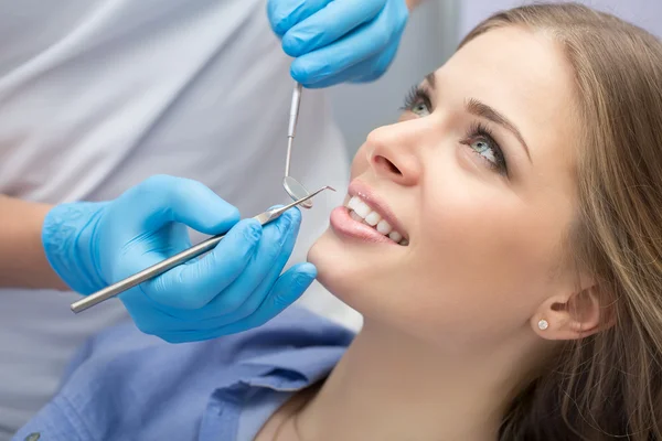 Dentista che esamina un paziente denti nel dentista. — Foto Stock