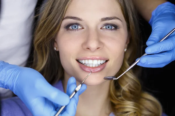 Dentista examinando los dientes de un paciente en el dentista. —  Fotos de Stock