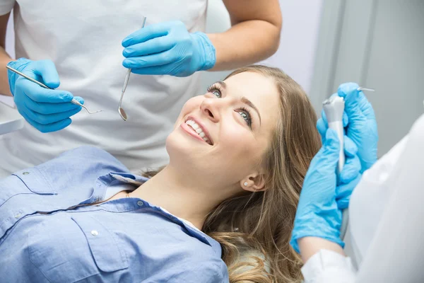 Tandläkare undersöker en patient tänder i tandläkaren. — Stockfoto