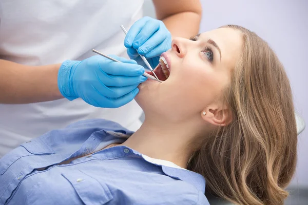 Dentista che esamina un paziente denti nel dentista. — Foto Stock