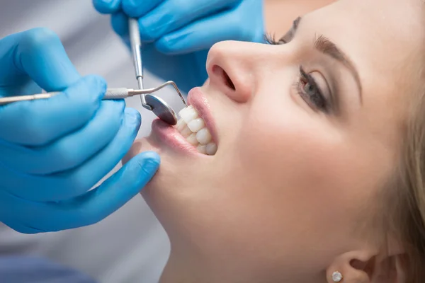 Dentista che esamina un paziente denti nel dentista. — Foto Stock