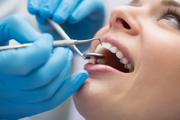 Dentista examinando los dientes de un paciente en el dentista. — Foto de Stock