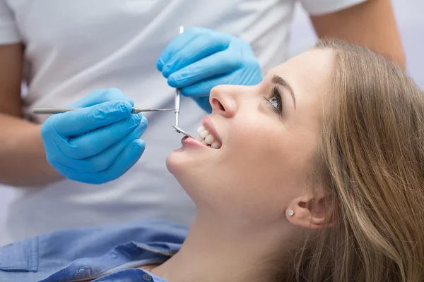 Dentista che esamina un paziente denti nel dentista. — Foto Stock