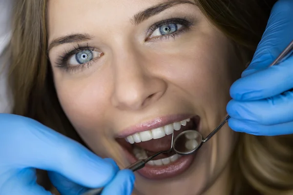 Dentista che esamina un paziente denti nel dentista. — Foto Stock