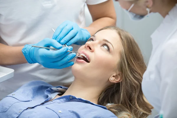 Dentista che esamina un paziente denti nel dentista. — Foto Stock