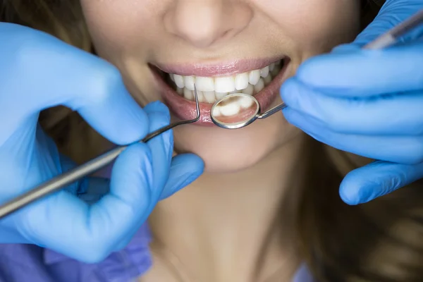 Dentista examinando los dientes de un paciente en el dentista. —  Fotos de Stock