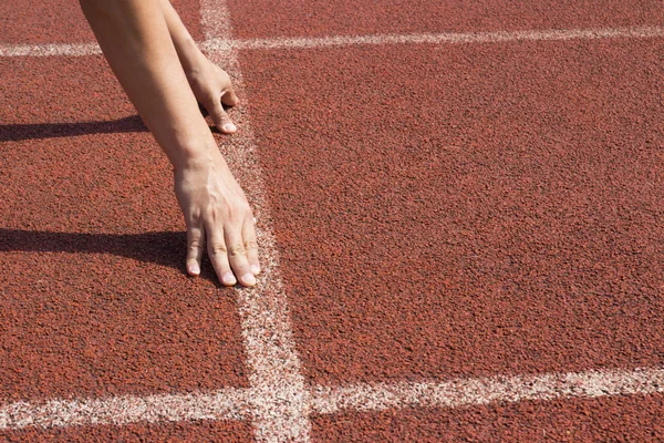 Atleet in de startblokken, klaar om te gaan Stockafbeelding