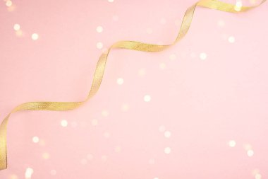 Parlak bir arka planda güzel altın bir kurdele, Yeni Yıl 'ın yanında. Yeni yıl içeriği. Düz yatıyordu