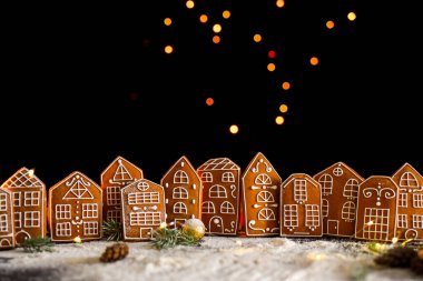 Pencerelerinden gelen ışığı, zencefilli kek şehrini, büyük yan ışıkları ve karı olan kış zencefilli kek evi. Yeni yıl içeriği. Noel kartı..