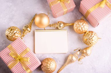 Boş beyaz çarşaflar ve altın yaylı güzel defterler Noel ağacı için altın oyuncaklar dekor ve ambalajlı güzel hediyeler. Yukarıdan görüntüle, metin için yer.