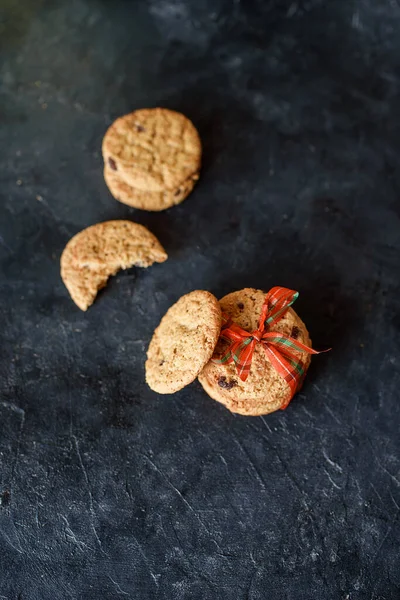 Deliciosas galletas de pan corto con trozos de chocolate, con una hermosa cinta sobre un fondo oscuro. Vista desde arriba — Foto de Stock