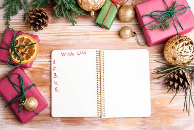 Tatil süslemeleri ve kırsal tablonun üzerinde dilek listesi olan bir defter. Yeni yıl kavramı