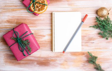 Tatil süslemeleri ve kırsal tablonun üzerinde dilek listesi olan bir defter. Yeni yıl kavramı