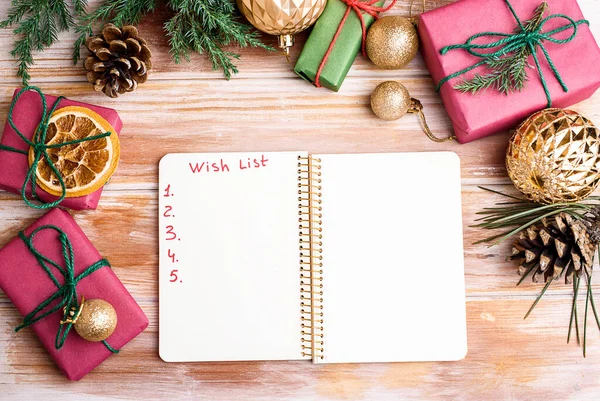 Tatil süslemeleri ve kırsal tablonun üzerinde dilek listesi olan bir defter. Yeni yıl kavramı