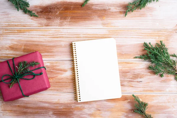 Holiday decorations and notebook with wish list on rustic table, flat lay style. New years concept