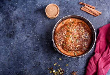 Limon aromalı balkabağı turtası, kabak tohumları, tarçın, kokulu baharatlar ve karanlık bir arka planda baharatlar. Sağlıklı ve lezzetli yemekler.